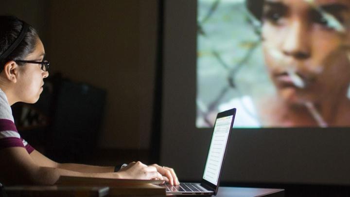 学生梅根·梅德拉诺在分析电影时使用她的笔记本电脑