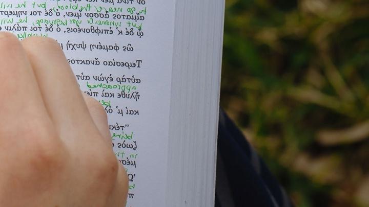 Linguistics student adds handwritten notes to his book.