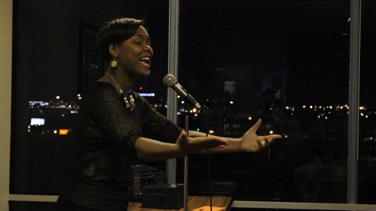 African American woman reading a poem at mic night