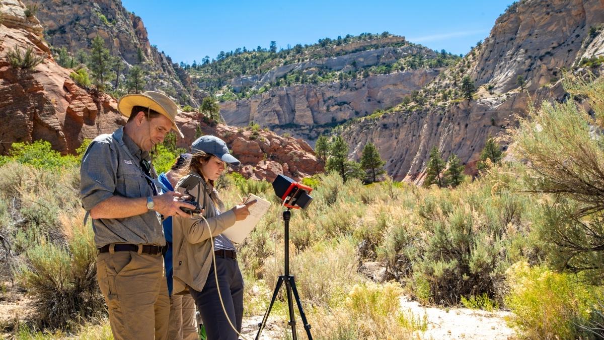 Professor and students taking measurements in canyon