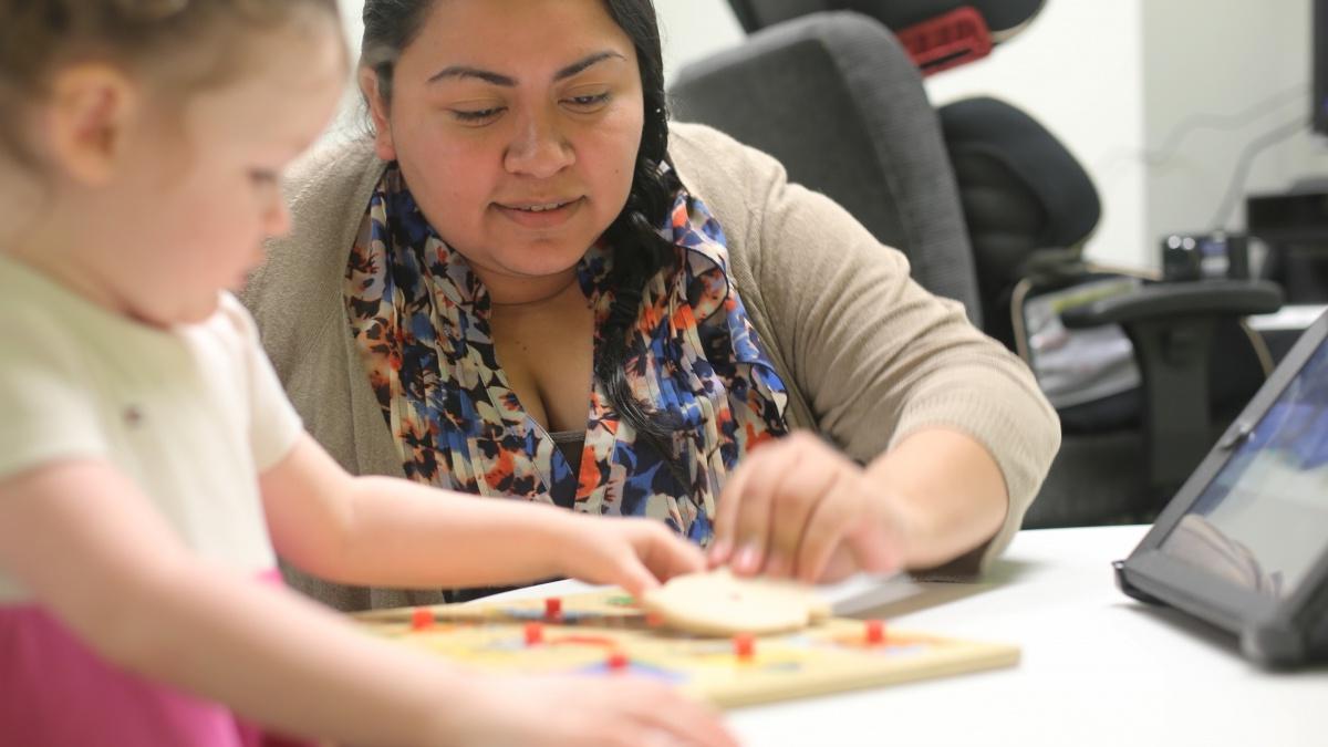 Student with a child working through puzzle